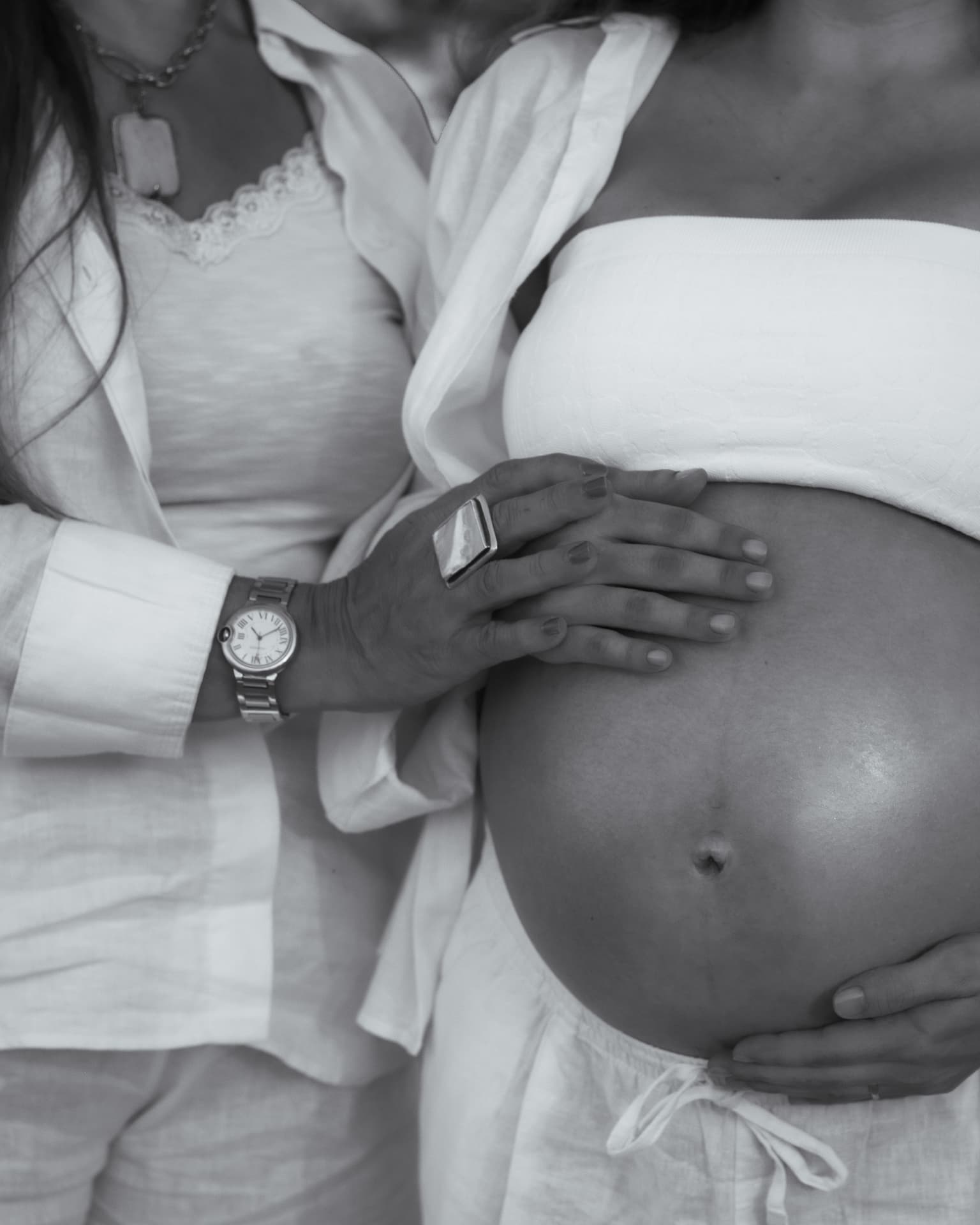 Ensaio gestante — detalhe em preto e branco das mãos sobre a barriga
